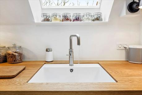 vigas de madera techo inclinado interior abierto encimera de madera decoración nórdica cocina nórdica cocina moderna cocina en forma de L cocina blanca ático dúplex 