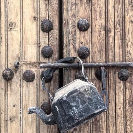 puerta antigua de madera, tetera de zinc, herrajes