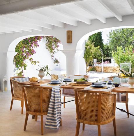 Porche en blanco estilo ibicenco con comedor con mesa de madera de madera y butacas_ 00346850