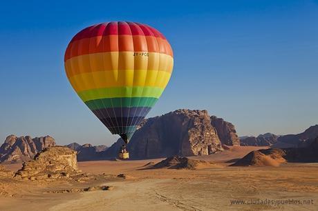 A family flying over Wadi Rum National Reserve, which is also known as The Valley of the Moon, in a colourful hot air balloon.