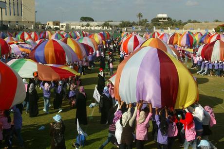 La industria de la Nakba: el negocio de los refugiados. Niños palestinos realizan con paracaídas durante las actividades del campamento de verano supervisadas por la UNRWA en Khan Yunis, en el sur de la Franja de Gaza, 30 de junio de 2011. Trataron de romper el récord mundial Guinness para la mayoría de los paracaídas se recuperaron de forma simultánea. Foto por Abed Rahim Khatib / Flash90
