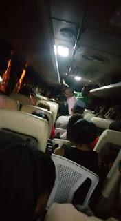 Sillas en pasillo de autobús para pasajeros.