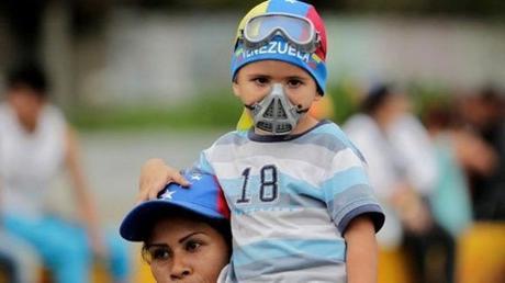 Una madre con su hijo disfrazado de “guarimbero” en una marcha convocada por la oposición. Foto: Facebook