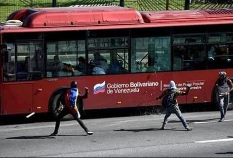 Un grupo de adolescentes lanzan cócteles molotov y piedras contra un bus en Caracas. Foto: Twitter