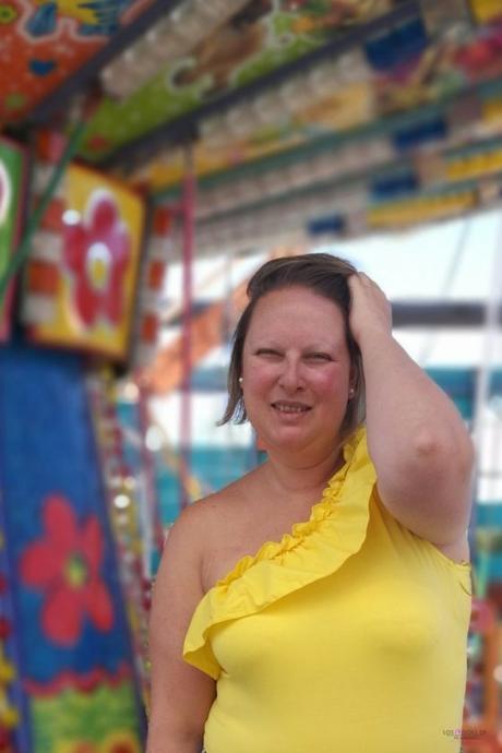 look verano con body amarillo con volantes de primark con falda de rayas y capazo redondo de mimbre y sandalias negras en un carrusel