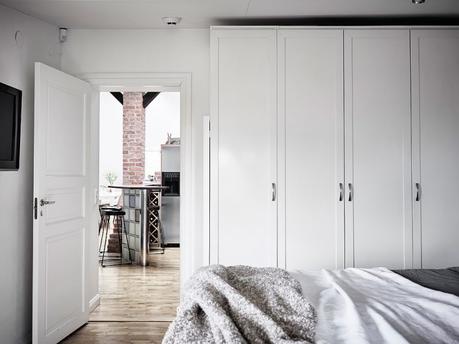 vigas en el techo salon chimenea ladrillo visto estufa de leña estilo nórdico decoración terrazas decoración áticos cenas en la terraza atico escandinavo 