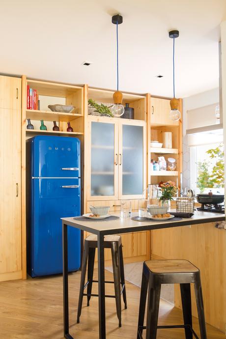 00447152. Cocina de madera con nevera azul y mesa metálica como office 00447152