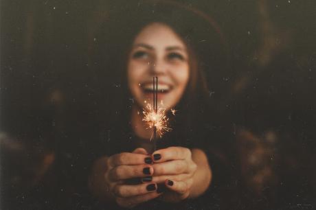 Chica con sombrero sonriendo feliz, con chispas, estrellitas riendo de felicidad