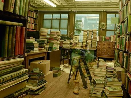 Liu Bolin camuflado entre libros y fotografiado por Annie Leibovitz