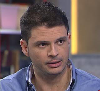 Foto de Alfonso Barán, filósofo y escritor. Es un adulto con apariencia de joven. Lleva el pelo corto y una barba muy fina, viste con una camisa de color azulado.