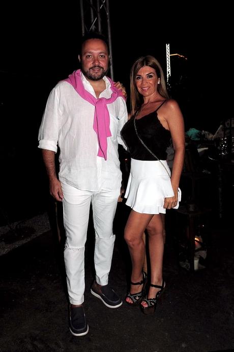 Diego Cani con total white, jeans con corte en las rodillas y camisa de lino blanca acompañado por un cardigan de hilo en rosa, y Lina Anllo en bicolor, falda blanca y top lencero negro junto a plataformas de madera y charol.
