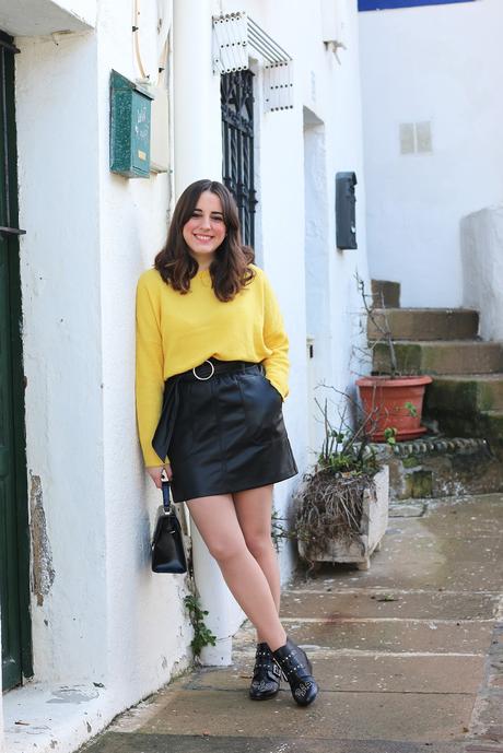 Outfit con jersey amarillo y falda de cuero