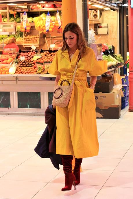 vestido midi amarillo y botas altas con parka