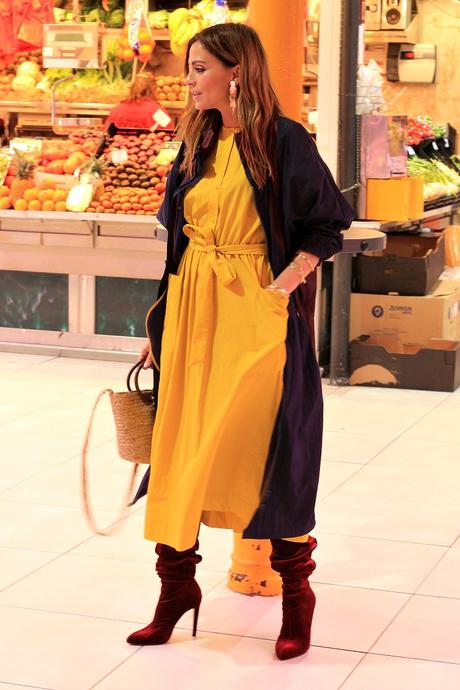 vestido midi amarillo y botas altas con parka