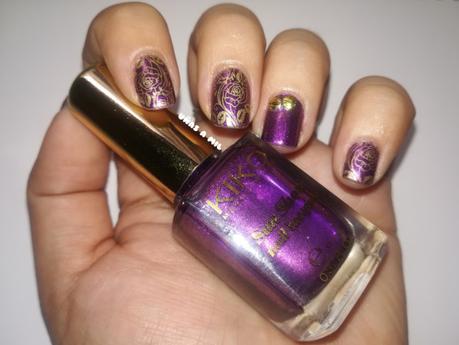 Diseño de uñas en morado y dorado con tachuelas