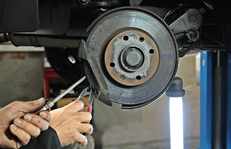 Revisando los frenos para el mantenimiento del coche