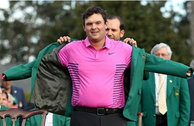 El gesto de felicidad de Patrick Reed, que extiende sus brazos para que Sergio GarcÃ­a, el campeÃ³n Ãºltimo del Major, le coloque el tradicional saco verde