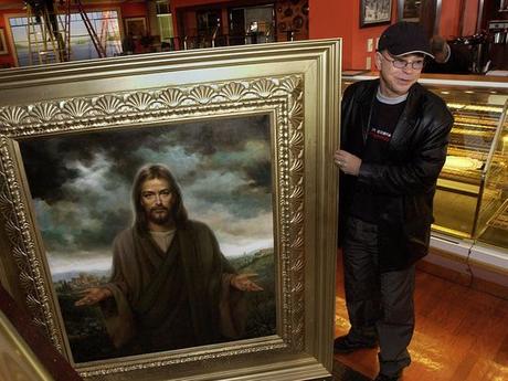 En esta foto de 2002, Jim Bakker sostiene una de las pinturas