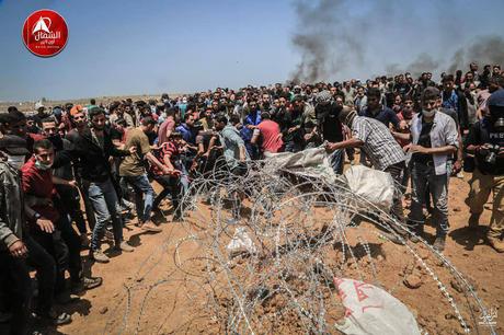 manifestantes palestinos intentan cortar la cerca de alambre de púa durante los enfrentamientos al este de Jabalia (página Facebook de Beit Hanoun News, 14 de mayo de 2018).