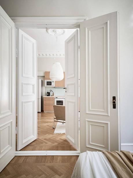 suelo de madera espigada puertas dobles interior Molduras en el techo grandes ventanales distribución diáfana detalles arquitectonicos chimenea sueca   