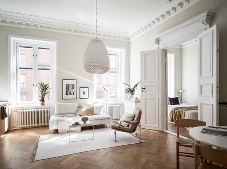 suelo de madera espigada puertas dobles interior Molduras en el techo grandes ventanales distribución diáfana detalles arquitectonicos chimenea sueca   