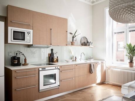 suelo de madera espigada puertas dobles interior Molduras en el techo grandes ventanales distribución diáfana detalles arquitectonicos chimenea sueca   