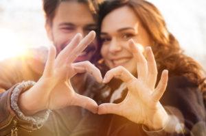 10 Consejos para mantener enamorado a un hombre Closeup of couple making heart shape with hands