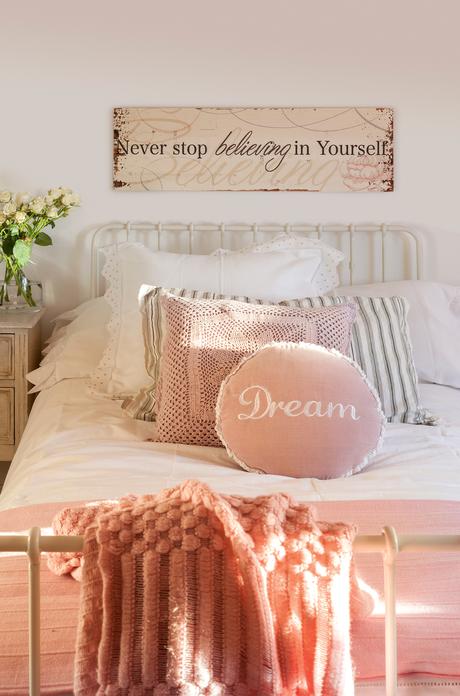 Semitoma de dormitorio con cama de forja y ropa de cama blanca y rosa. Semitoma de dormitorio con cama de forja y ropa de cama blanca y rosa_00395609