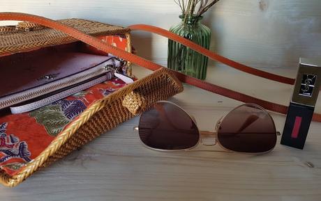 Un bolso de mimbre, un pintalabios, unas gafas de sol y unos zapatos