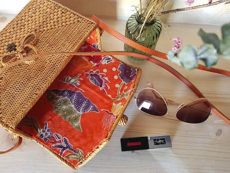 Un bolso de mimbre, un pintalabios, unas gafas de sol y unos zapatos Un bolso de mimbre, un pintalabios, unas gafas de sol y unos zapatos