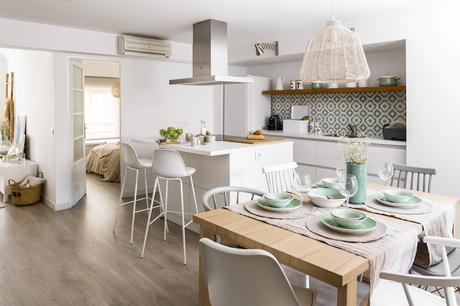 Cocina abierta y comedor con mesa de madera donde se ve la distribución Kenay Home