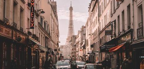 View of the Eiffel Tower through a crowded city street