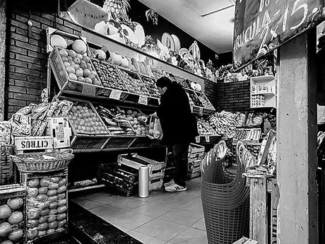 En una verdulería una mujer comprando.BYN