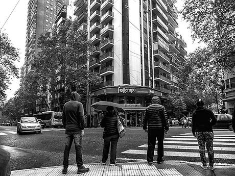 ByN.Gente esperando en la esquina mientras llueve