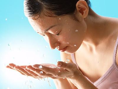 Chica refrescándose el rostro con agua Chica refrescándose el rostro con agua