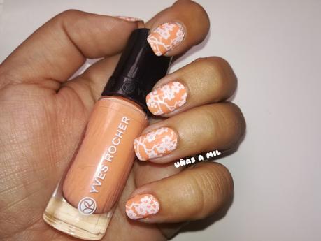 Diseño de uñas en naranja con flores blancas