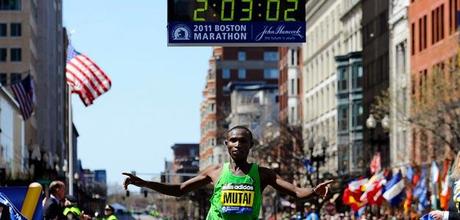 Momento en que Mutai cruza la meta de Boston con su récord reflejado en la parte superior