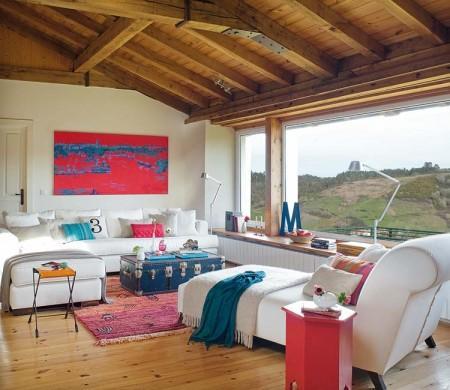 Una casa rural que rompe con el estilo rústico tradicional vigas de madera ventanas abiertas en el tejado una casa en el campo techo de madera techo abuhardillado suelo de barro sillas Tolix serigrafías de Andy Warhol muebles de ikea estilo rústico moderno diseño de interiores decoración en rosa y turquesa decoración de interiores cocina rústica cocina con frentes de rejilla chaise longue blanca accesorios de ikea