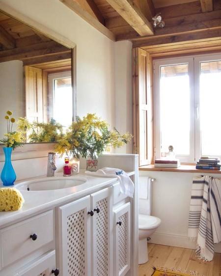 Una casa rural que rompe con el estilo rústico tradicional vigas de madera ventanas abiertas en el tejado una casa en el campo techo de madera techo abuhardillado suelo de barro sillas Tolix serigrafías de Andy Warhol muebles de ikea estilo rústico moderno diseño de interiores decoración en rosa y turquesa decoración de interiores cocina rústica cocina con frentes de rejilla chaise longue blanca accesorios de ikea