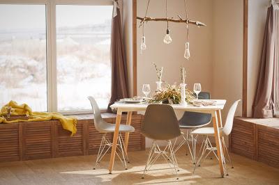 Mesa de comedor con platos, cubiertos, copas y decoración