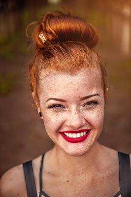 Chica con pecas mostrando una gran sonrisa