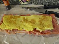 Redondo de lomo relleno con tortilla, queso,  jamón serrano y salsa de pimientos del piquillo sin lactosa