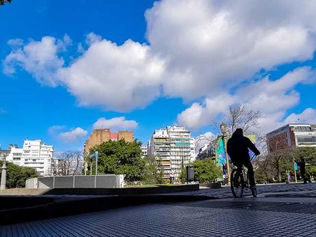 De espaldas a la sombra un cioclista parece contemplar el paisaje con nubes a pleno sol.