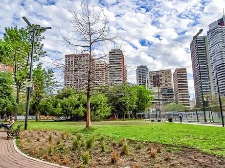 Vista desde el Parque con cielo con nubes y edificios rode{andolo.