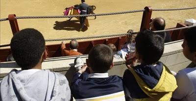 Unos niños, presenciando una corrida de toros.
