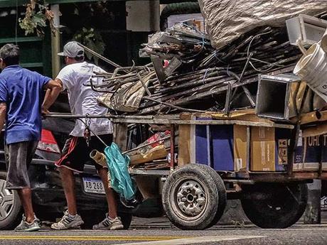 Dos cartoneros tirando un carro cargado por Buenos Aires