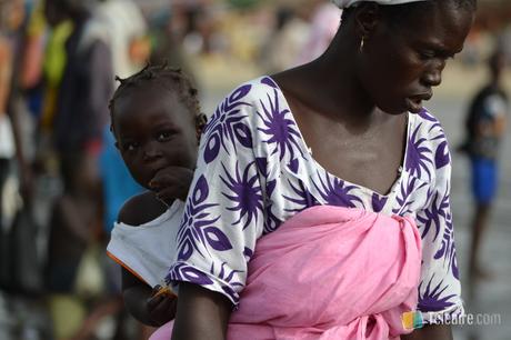 Las gambianas suelen llevar a los niños en la espalda