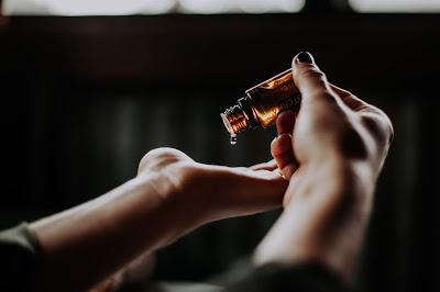 Poniéndose unas gotas de aceites esenciales en la palma de la mano