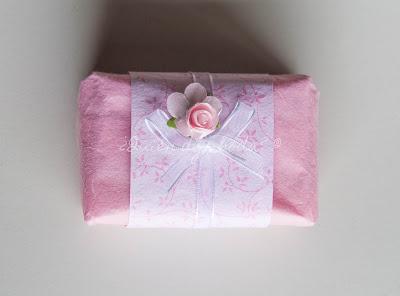 Jabón envuelto en papel de seda con detalles de papel decorativo, lazo y flores