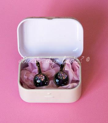 Caja metálica con pendientes sobre papel de seda